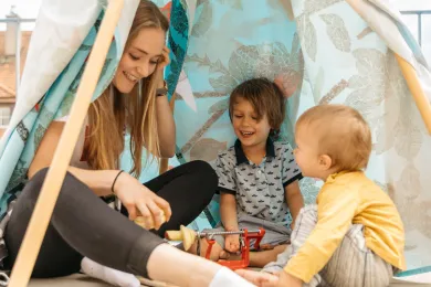 Eine Babysitterin betreut zwei Kinder.
