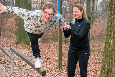 Eine Freiwille des Roten Kreuzes Zürich trainiert mit ihrem Mentee im Wald.