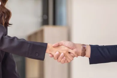 Zwei Personen, die sich die Hände schütteln.