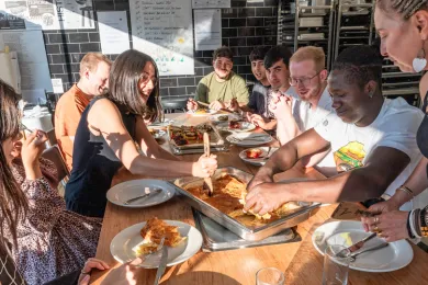 Gemeinsam essen Teilnehmende und Freiwillige am gedeckten Tisch
