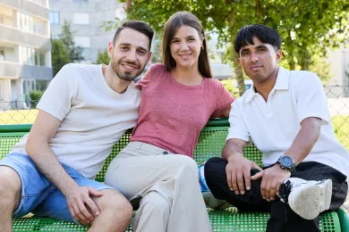 Drei Personen auf einer Sitzbank im Park