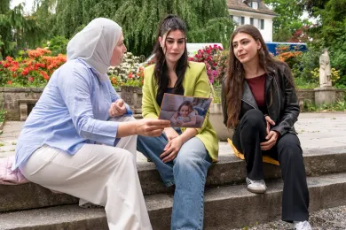 Drei Frauen im Gespräch in einem Park