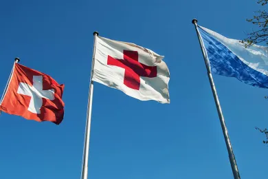 Eine Fahne der Schweiz, des Roten Kreuzes und des Kantons Zürich 