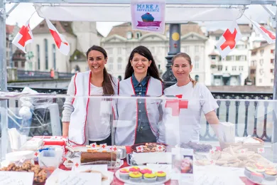 Drei Frauen verkaufen Kuchen an einem Stand in der Stadt neben der Limmat.