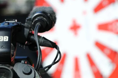 Eine Kamera filmt einen Rotkreuz-Stand