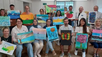 Tandems von «come together» zeigen ihre selbstgemalten Bilder, die am Community Event entstanden sind. 