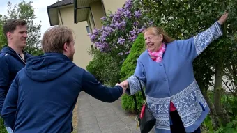 Eine Frau, die Fahrgast ist beim Zürcher Rotkreuz-Fahrdienst, wird von zwei prominenten Spielern des EHC Kloten begrüsst.