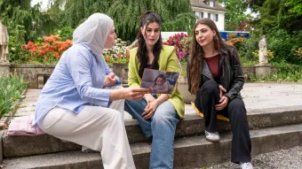 Drei Frauen im Gespräch in einem Park