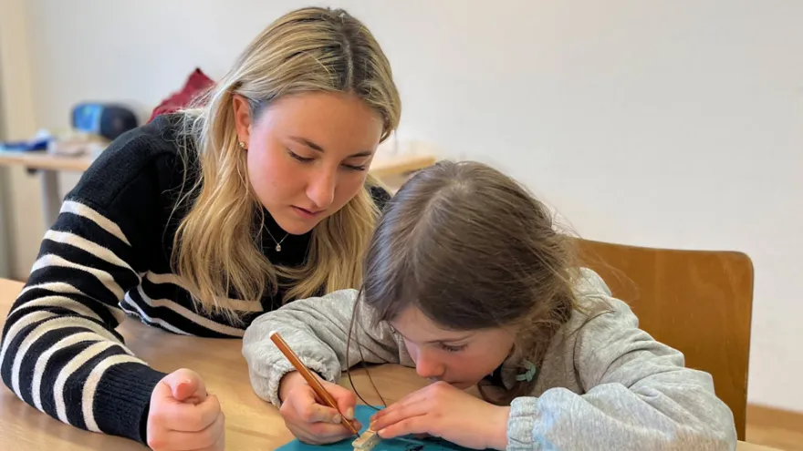 Eine Sprachtreff-Freiwillige mit einem Kind beim Basteln