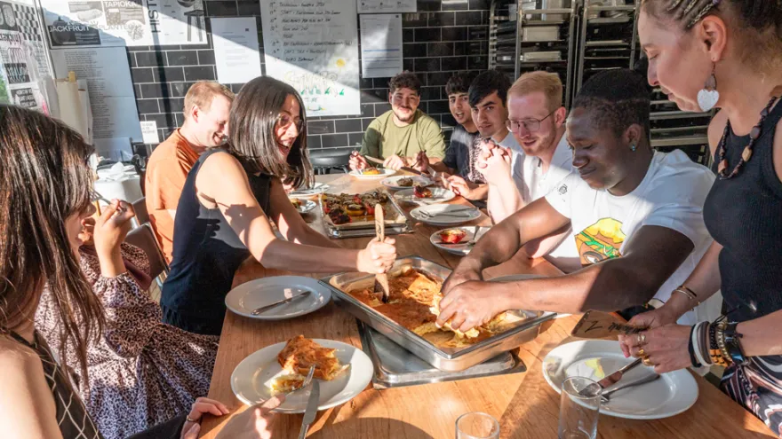 Gemeinsam essen Teilnehmende und Freiwillige am gedeckten Tisch