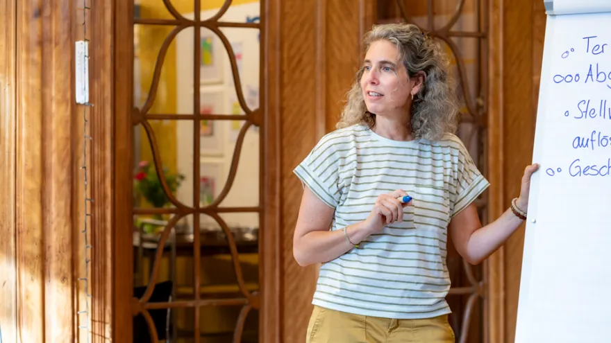 Eine Frau steht vor dem Flipchart