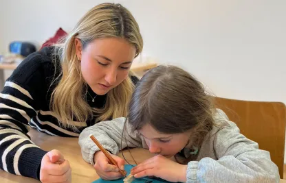 Eine Sprachtreff-Freiwillige mit einem Kind beim Basteln