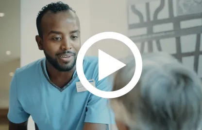 Ein Pflegefachmann spricht mit einer Bewohnerin